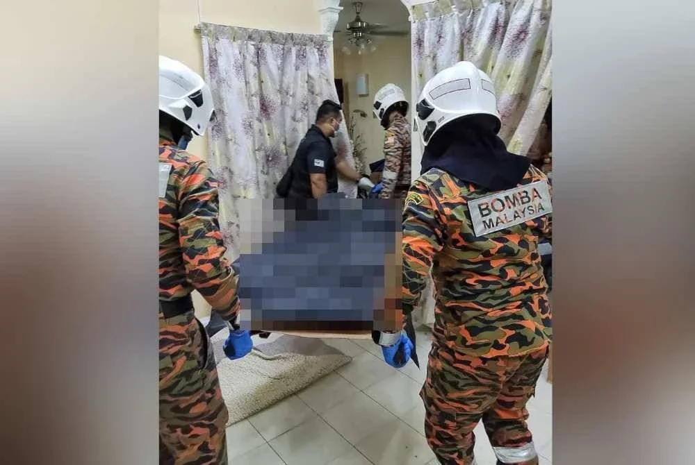 Anggota polis dan pasukan bomba mengangkat mayat wanita itu yang ditemui terbaring di dalam rumah.