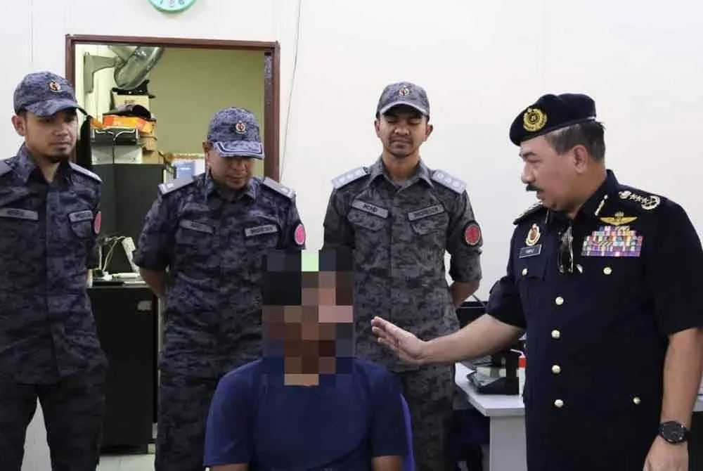 Muhammad Kifli (kanan) menemu bual pemandu warga asing kenderaan perdagangan yang ditahan. Foto JPJ