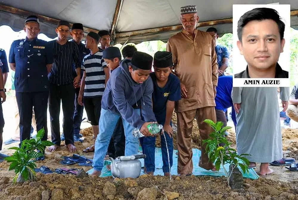 Anak-anak Allahyarham Koperal Mohd Hafizul Izham Mazlan, Muhammad Akif Naufal,11, dan Muhammad Ammar Nazran, 9, menyiram air pada pusara ayah mereka pada istiadat pengebumian kepahlawanan Polis Diraja Malaysia (PDRM) bapa mereka di Tanah Perkuburan Islam Putera Jaya pada Jumaat. Foto Bernama