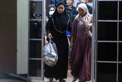 Penyanyi dikir barat Eda Ezrin (kiri) atau nama sebenarnya Wan Norshaheeda Azlin Wan, bersama ibunya Zahara Mamat, 47, setelah selesai diambil keterangan oleh pihak polis selama lebih tiga jam di Balai Polis Rantau Panjang malam Khamis. Foto Bernama.