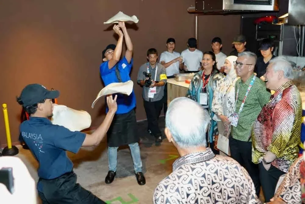 Tengku Zafrul menyaksikan pertunjukan roti canai terbang yang merupakan tarikan utama Pavilion Malaysia di Ekspo 2025 Osaka.