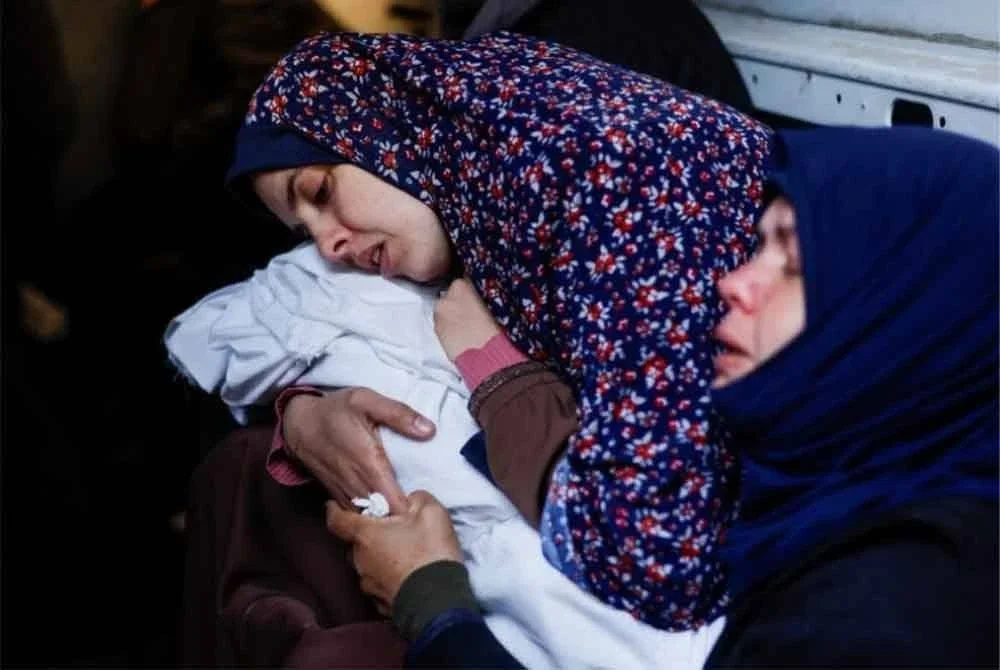 Seorang ibu memeluk bayinya yang meninggal dunia.