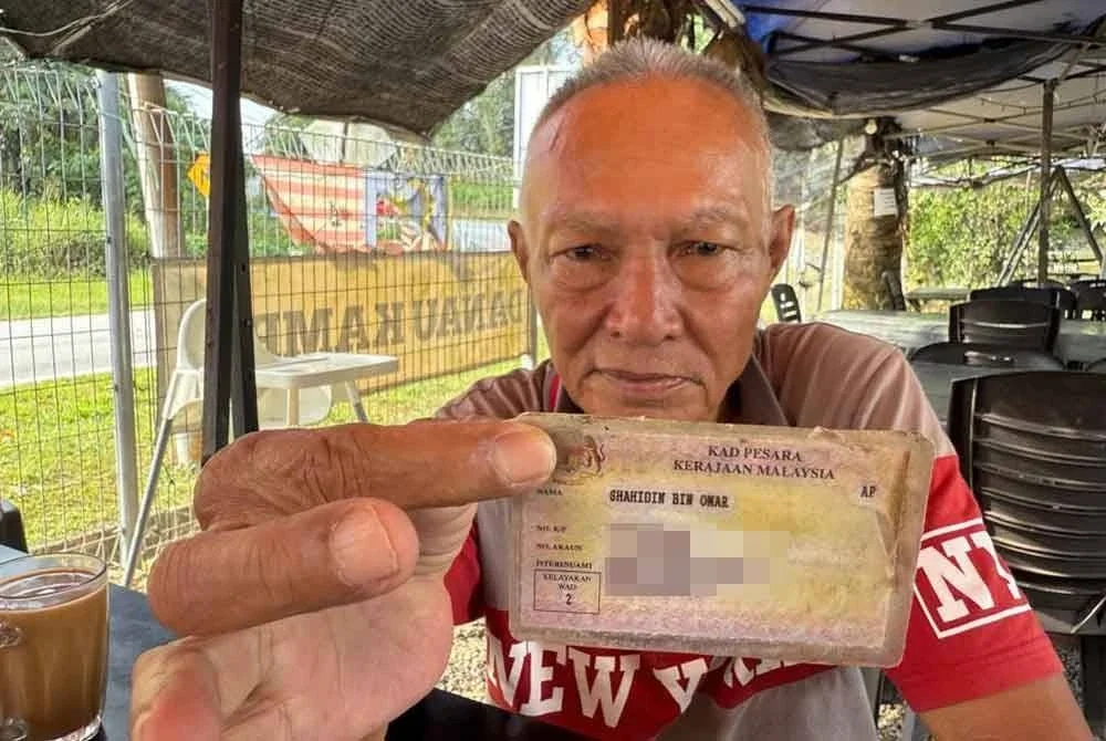 Shahidin menunjukkan kad pesara.