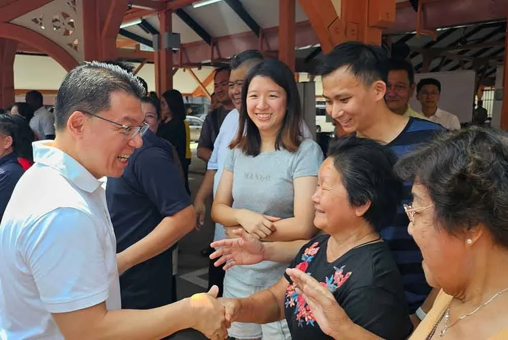 Kor Ming (kiri) bersalaman dengan peniaga Pusat Penjaja Siang Malam dan pengunjung pada Program Sentuhan Kasih 3.0 2025 di Pasar Lama Taiping pada Sabtu.