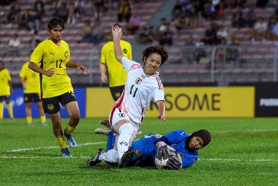 Penjaga gol Malaysia Nurdiana Mohd menyelamatkan serangan pemain Jepun Yuka Kurimoto pada perlawanan Kumpulan F Kelayakan Piala Asia Wanita Bawah 20 di Stadium Bola Sepak Kuala Lumpur, malam ini. Keputusan perlawanan, Malaysia 0-16 Jepun. Foto Bernama