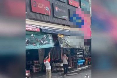 Tangkap layar video tular memaparkan perbuatan seorang lelaki yang sengaja mengibarkan Jalur Gemilang secara terbalik.