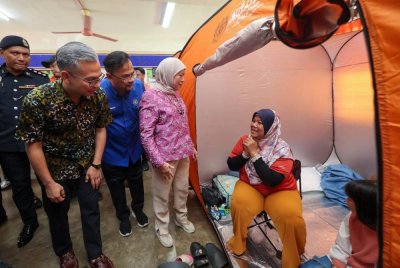 Nancy (dua dari kanan) bersama Fahmi (kiri) menyantuni mangsa kebakaran yang ditempatkan di PPS Sekolah Rendah Agama Al-Khawarizmi, Kuala Lumpur pada Sabtu. Foto Bernama