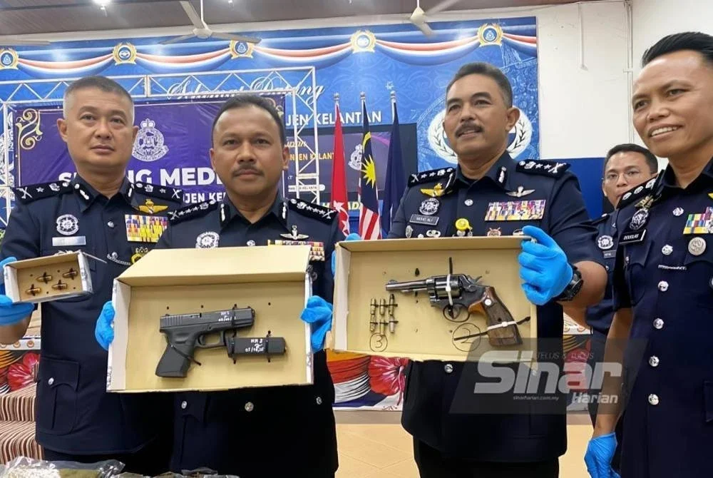 Mohd Yusoff (dua,kiri) menunjukkan dua pucuk pistol yang dirampas dalam dua serbuan berasingan iaitu di Ketereh, Kota Bharu (kiri) dan Pengkalan Kubor, Tumpat (kanan) semasa sidang akhbar di IPK Kelantan, Kota Bharu pada Ahad.