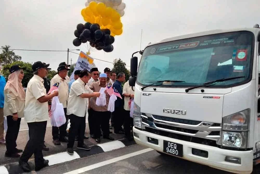 Alexander (empat, kiri) menyampaikan cenderamata kepada pemandu sempena Majlis Penyerahan Projek Siap Menaiktaraf Laluan FT003 dari Persimpangan Melor, Ketereh ke Kampung Pak Badol pada Ahad.