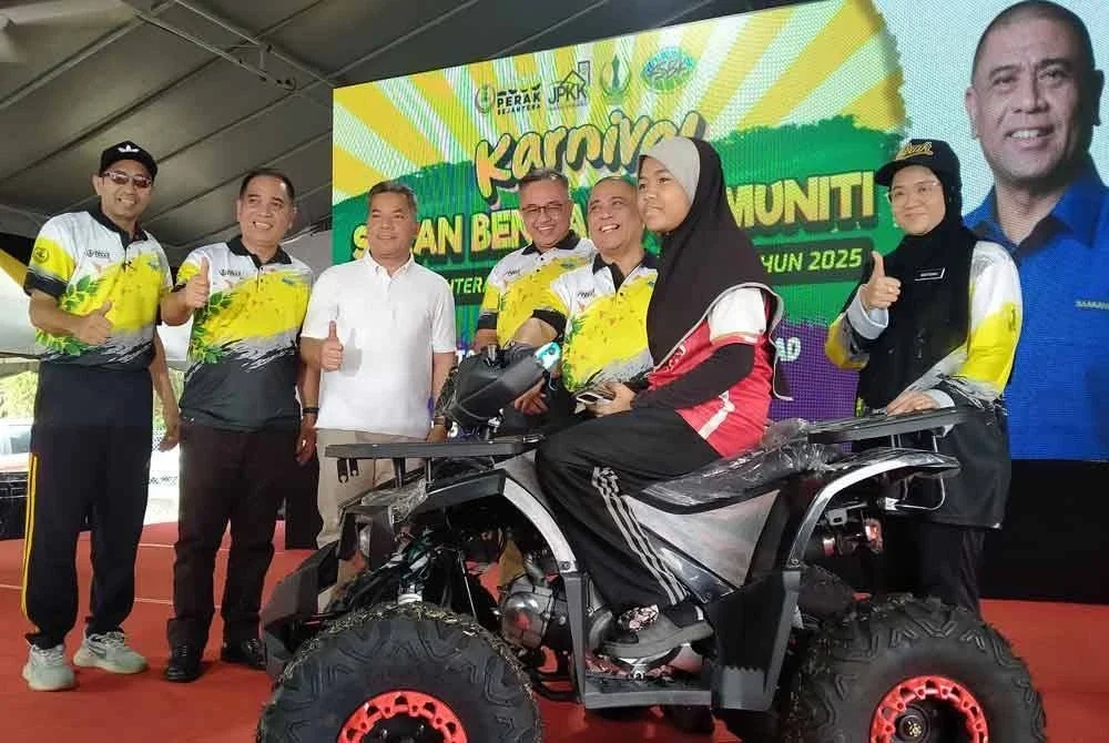 Saarani (tiga dari kanan) menyampaikan hadiah utama cabutan bertuah berupa ATV kepada pemenang selepas merasmikan Karnival Sukan Bendang Komuniti Perak Sejahtera 2030 Peringkat Daerah Hilir Perak di Sekolah Kebangsaan Permatang, Parit 7B Sungai Manik, Pasir Salak pada Ahad.