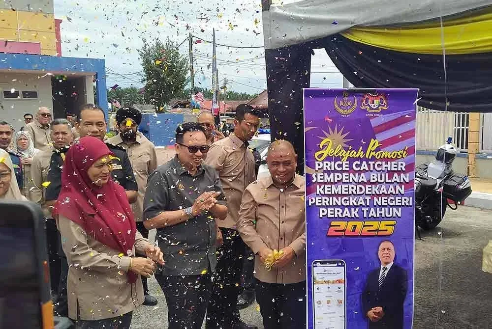Saarani (kanan) sambil ditemani Kamalludin menyempurnakan pelancaran Jelajah Promosi Price Catcher sempena Bulan Kemerdekaan Peringkat Negeri Perak di Dewan Majlis Perbandaran Teluk Intan (MPTI), Langkap pada Isnin.