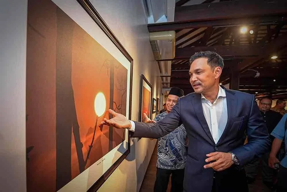 Hans Isaac (kanan) melihat pameran fotografi ketika hadir merasmikan Pameran Ekspresi Emosi Warna (EEW20205) di Galeri Shah Alam. - Foto: Bernama