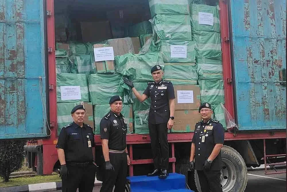 Shazeli (dua dari kanan) menunjukkan muatan rokok tidak bercukai yang dirampas polis 3 Ogos lalu.