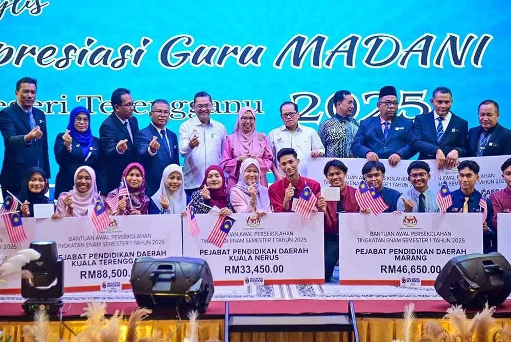 Mohd Azam (lima dari kanan) merakam gambar bersama penerima bantuan awal persekolahan tingkatan enam pada Majlis Apresiasi Guru Madani Terengganu 2025 di Kuala Terengganu pada Isnin.