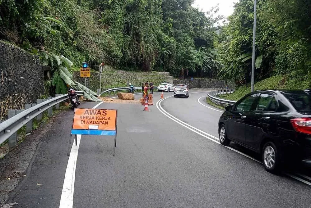Sebuah bongkah batu besar terjatuh dari lereng bukit ke atas jalan raya di Kilometer 1.0, Jalan Tun Sardon dari arah Balik Pulau menuju ke Paya Terubong pada pagi Isnin.