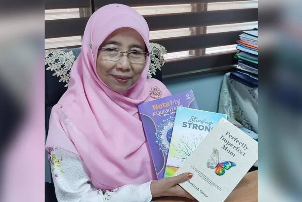 Azlina menunjukkan beberapa buku ditebusnya menggunakan Baucar Buku Guru Madani.