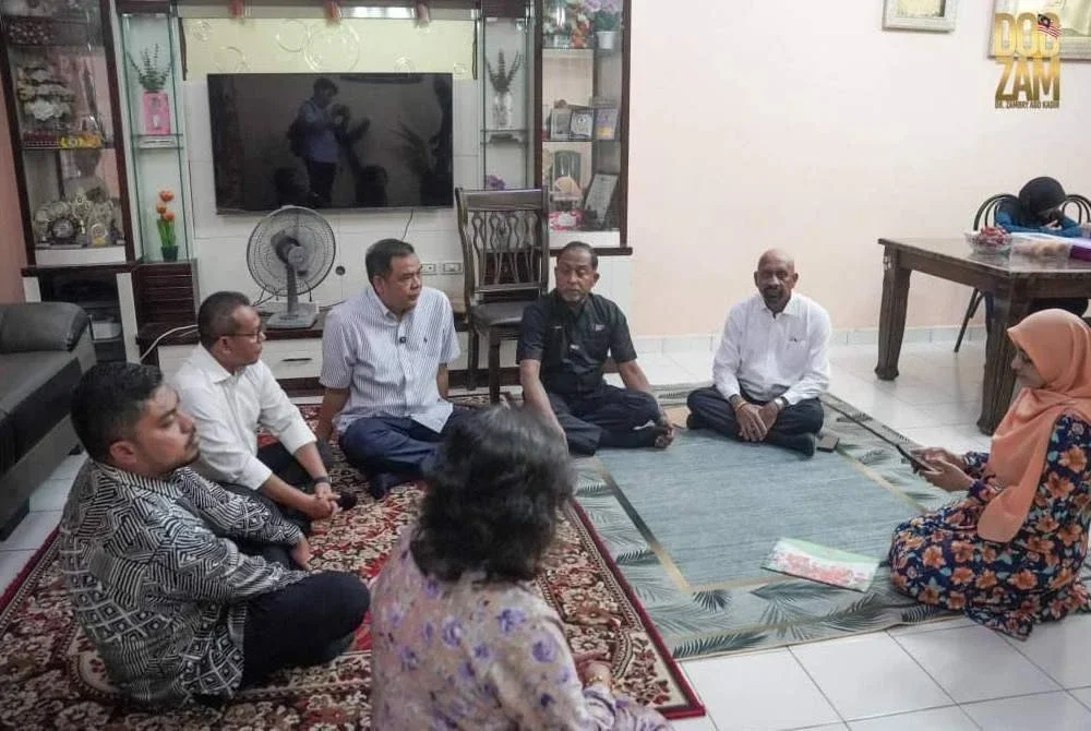 Pengurusan UTM mengiringi Zambry (tiga dari kanan) menziarahi Ummu Haiman Bee di kediamannya di Semenyih, Selangor pada Isnin - Foto UTM