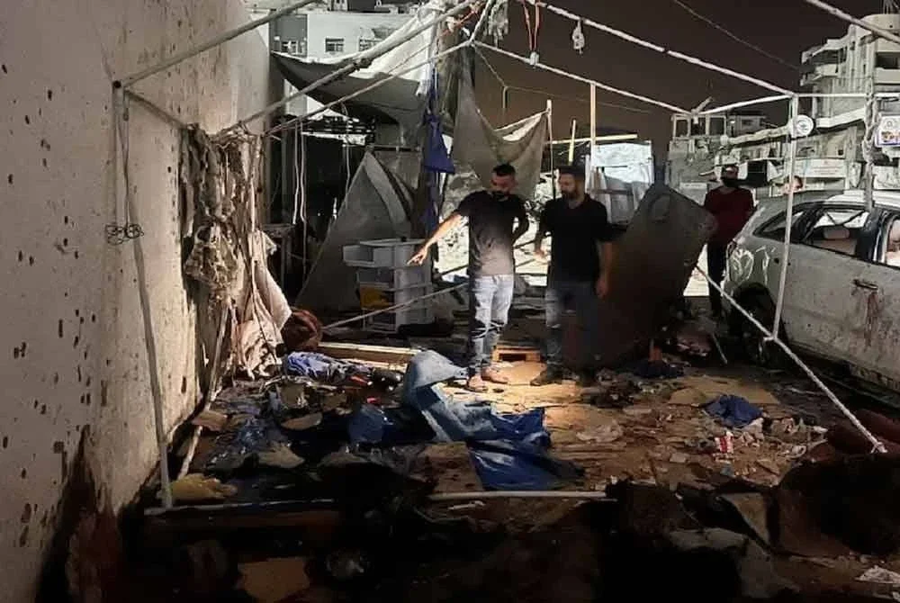 Penduduk Palestin memeriksa tapak serangan Israel di mana Al Jazeera mengatakan wartawannya Anas Al Sharif, Mohammed Qreiqeh dan tiga wartawan foto terbunuh. - Foto REUTERS