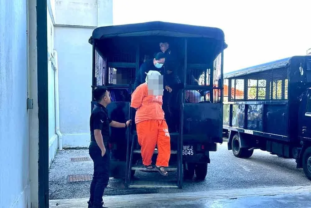 Isteri doktor dikawal polis ketika dibawa ke Mahkamah Majistret Kota Bharu pada Selasa untuk disambung reman selama enam hari.