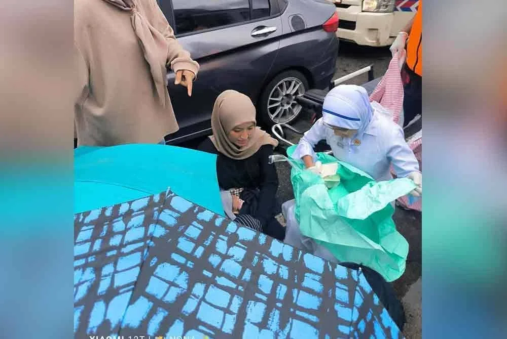 Petugas kesihatan tiba untuk membantu ibu berkenaan.