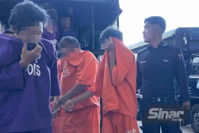 Suspek (dua dari kanan) dan abangnya (kiri) dikawal polis ketika menuju ke lokap mahkamah. (FOTO SINAR HARIAN - ADILA SHARINNI WAHID