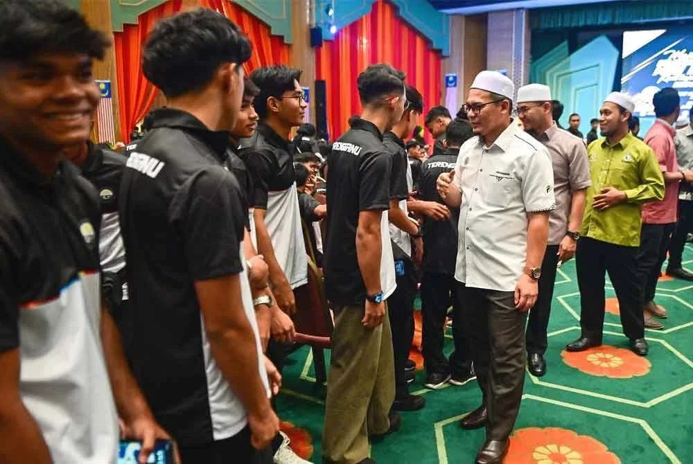 Hishamuddin (tiga dari kanan) bersalaman bersama barisan atlet sempena Majlis Selangkah Mencipta Gemilang – Misi Emas Bermula di Dewan Besar, Wisma Darul Iman, Kuala Terengganu.