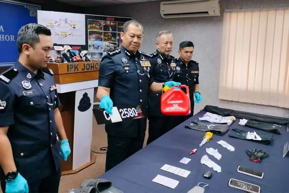 Ab Rahaman (dua dari kiri) menunjukkan tong minyak yang dirampas daripada suspek yang membakar rumah warga emas di Segamat.