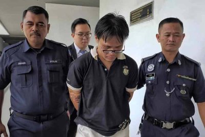 Kuan Jie (tengah) ketika dibawa keluar dari Mahkamah Majistret pada Rabu.