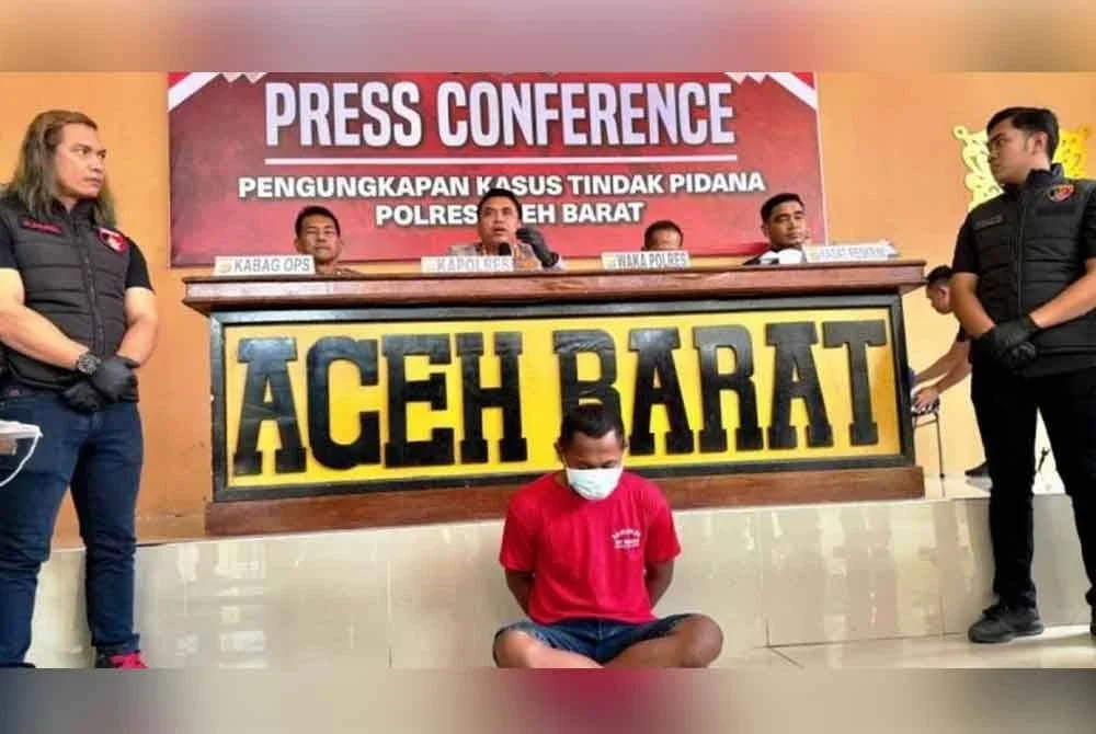 Suspek (tengah) ditahan pada 3 Ogos lalu dan kini berada dalam tahanan di Ibu Pejabat Polis Daerah Aceh Barat.- Agensi