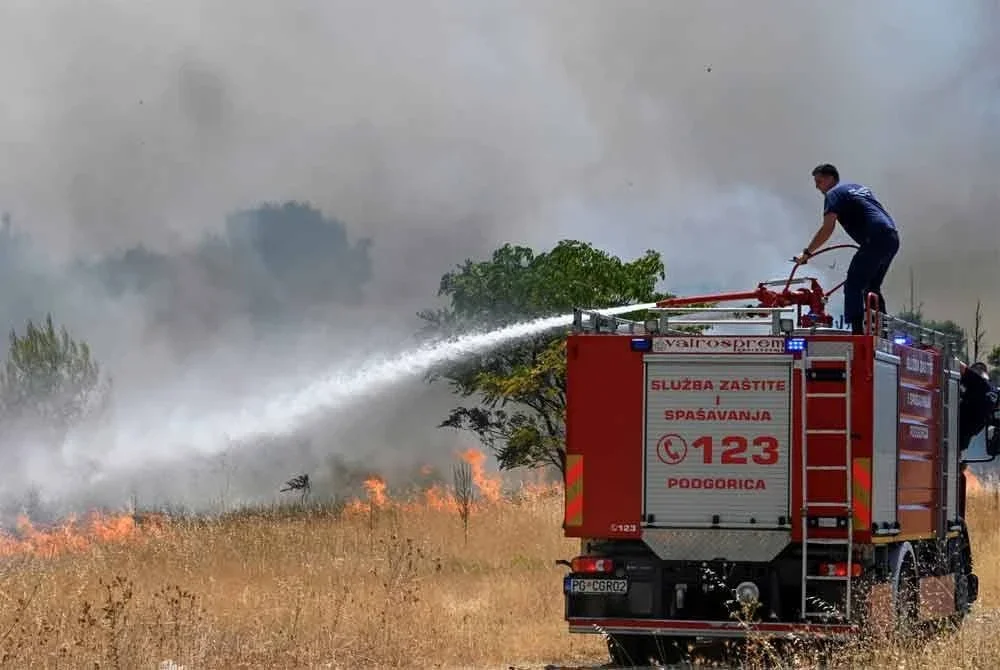 Anggota bomba memadam kebakaran hutan akibat cuaca panas dan rumput kering di pinggir Podgorica, Montenegro. - AFP
