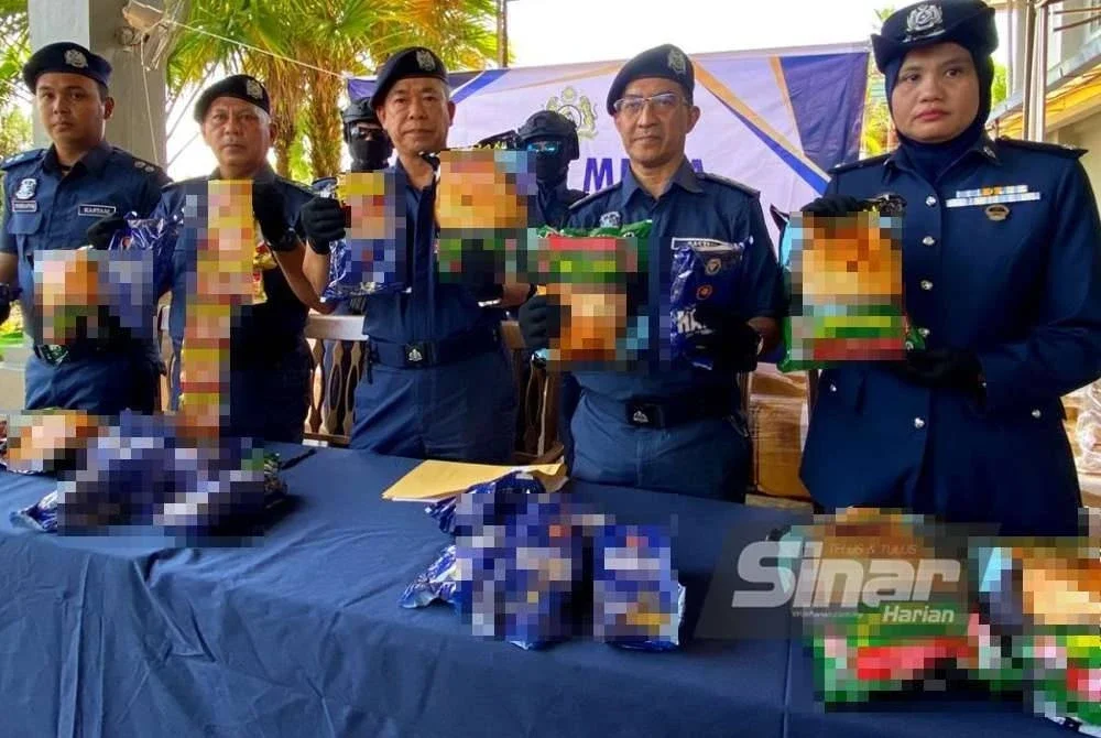 Wan Jamal Abdul Salam (tengah) menunjukkan sebahagian daripada tembakau kunyah yang dirampas.