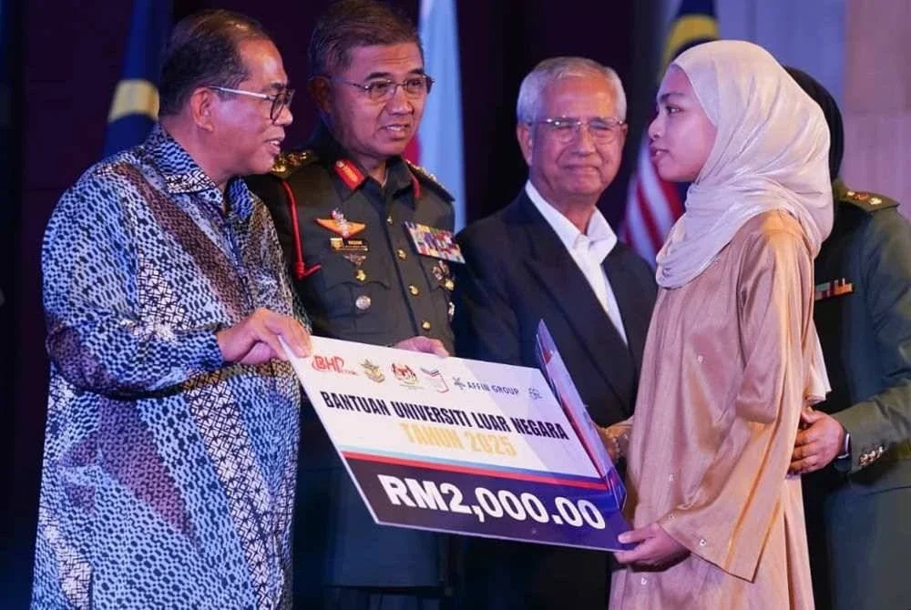 Haya Sofea (kanan) menerima bantuan Universiti Luar Negara disampaikan Mohamed Khaled (kiri) pada majlis berlangsung di Wisma Perwira ATM di ibu negara.