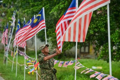 Raja Ismail tekun memasang Jalur Gemilang di sekitar kediamannya di Kuala Nerus baru-baru ini.