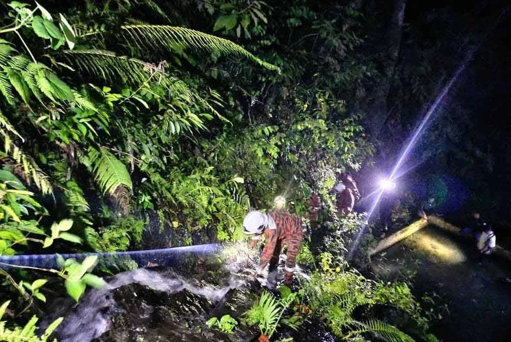 Anggota bomba menggunakan pengusung dan sistem tali untuk membawa mangsa turun dari kawasan puncak air terjun.