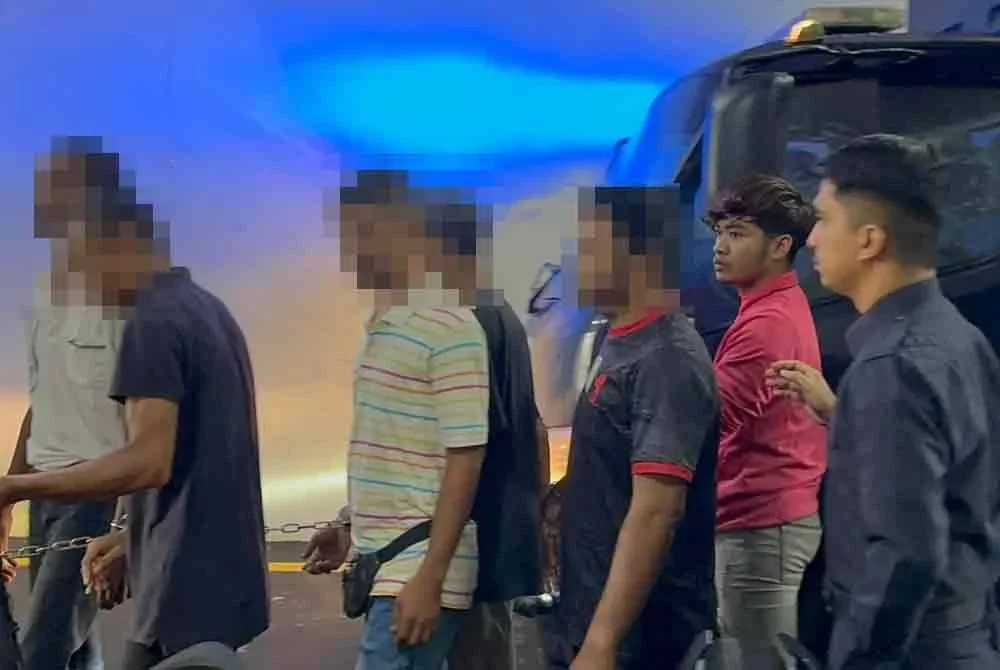 Mohamad Yusri (dua dari kanan) diiringi polis ketika dibawa ke Mahkamah Butterworth, pada Jumaat.