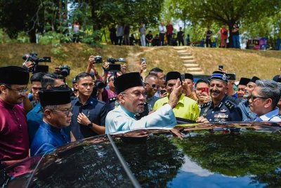 Anwar menyantuni jemaah selepas menunaikan solat Jumaat di Surau Al-Muttaqin 5R6 Putrajaya. Foo Bernama