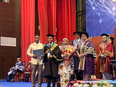 Muhammad Fathur (dua dari kiri) bergambar bersama Rubiah (depan, kanan) pada Majlis Konvokesyen Kolej Universiti Agrosains Malaysia (UCAM) kali Ke-21 yang diadakan di sini, Khamis.