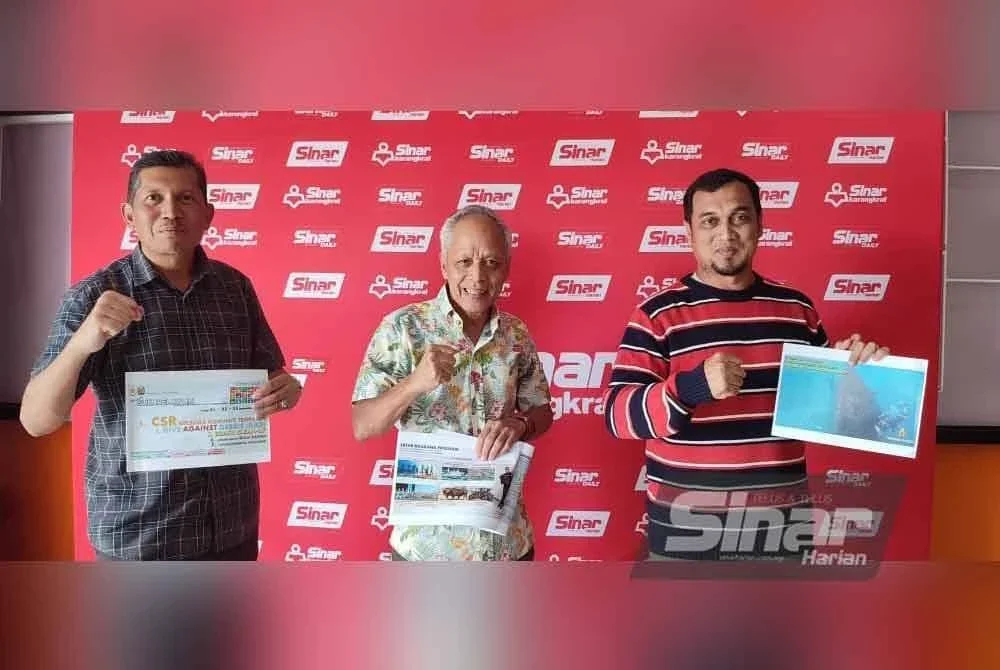 Muhammad Nasir (tengah) bersama Mohamad Ridwan (kiri) menunjukkan infomasi berkaitan program ketika berkunjung ke Kompleks Karangkraf, Shah Alam pada Sabtu.