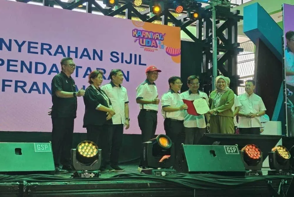 Ewon (lima dari kiri) menyampaikan sijil kepada usahawan yang terlibat dalam Karnival UDA Holdings Berhad bersama BizFrancias Pernas di Buhavan Square, Penampang.