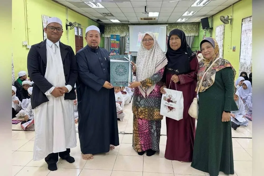 Wakil dari PRNNK (tiga dari kanan) menyampaikan cenderamata al-Quran kepada Muhammad Hafiz Hukmi (dua dari kiri) ketika Jelajah Kempen Malaysia #QuranHour 2025 oleh wakil Persatuan Rumah Ngaji Negeri Kelantan (PRNNK) di Pusat Pengajian Islam Tok Kenali, Kubang Kerian pada Ahad.