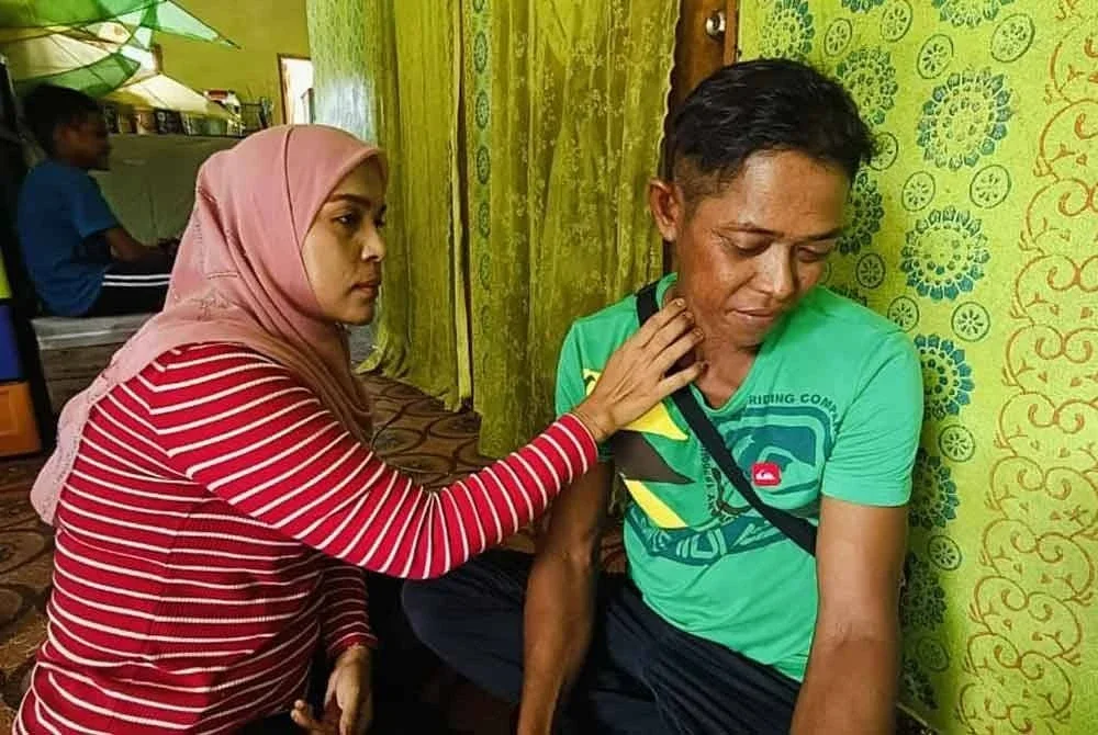 Suwanna menunjukkan benjolan di leher suaminya, Hairun, yang mengesahkan beliau menghidap kanser limfoma tahap empat sejak dua tahun lalu. Foto CSM