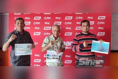 Muhammad Nasir (tengah) bersama Mohamad Ridwan (kiri) menunjukkan infomasi berkaitan program ketika berkunjung ke Kompleks Karangkraf, Shah Alam pada Sabtu.