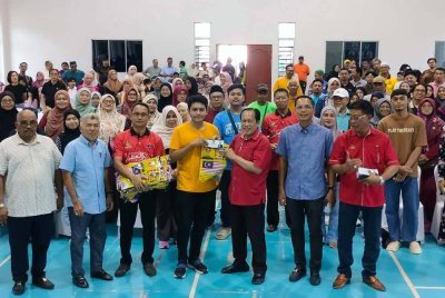 Ahmad (tiga dari kanan) menyampaikan sumbangan kepada 180 pelajar yang akan melanjutkan pengajian di universiti awam dan swasta di Dewan Kompleks Muafakat Sungai Pinggan, Benut pada Ahad.