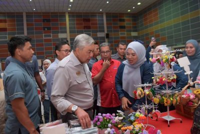 Ahmad Zahid (dua dari kiri) melawat reruai kraftangan yang dihasilkan Kemas ketika merasmikan Program Santunan Desa Kemas Negeri Perak Bersama JPKK dan Komuniti Kemas di Dewan Besar Felcra Changkat Lada, Pasir Salak pada Ahad. Foto Bernama