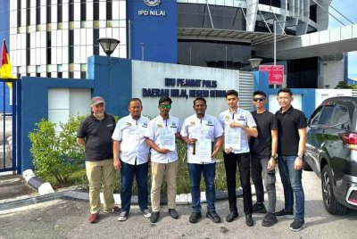 Syed Alwi (tengah) bersama Pemuda Kimma Negeri Sembilan membuat laporan polis di Ibu Pejabat Polis Daerah Nilai.