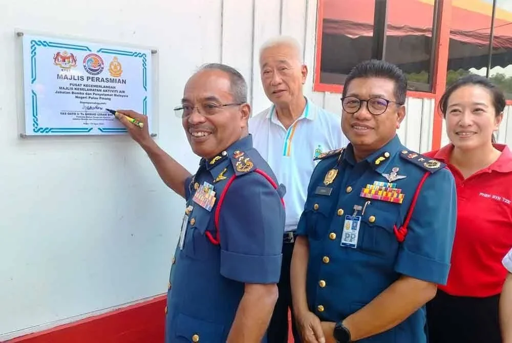 Ahmad Izram ketika menurunkan tandatangan pada plak perasmian Pusat Kecemerlangan Majlis Keselamatan Aktiviti Air (MKAA).
