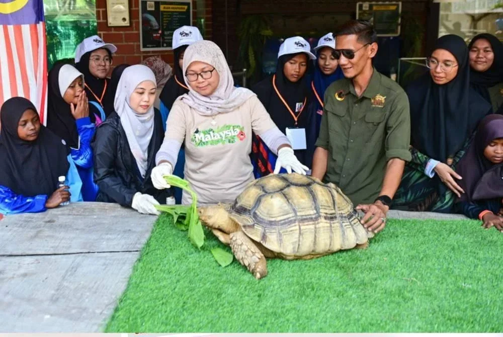 Mazshida (tengah) bersama pelajar yang menyertai aktiviti Kelab Program Pelancongan (K3P) mendengar penerangan mengenai penjagaan tuntung di Zoo Rimba Razia, Kampung Dusun, Hulu Terengganu.