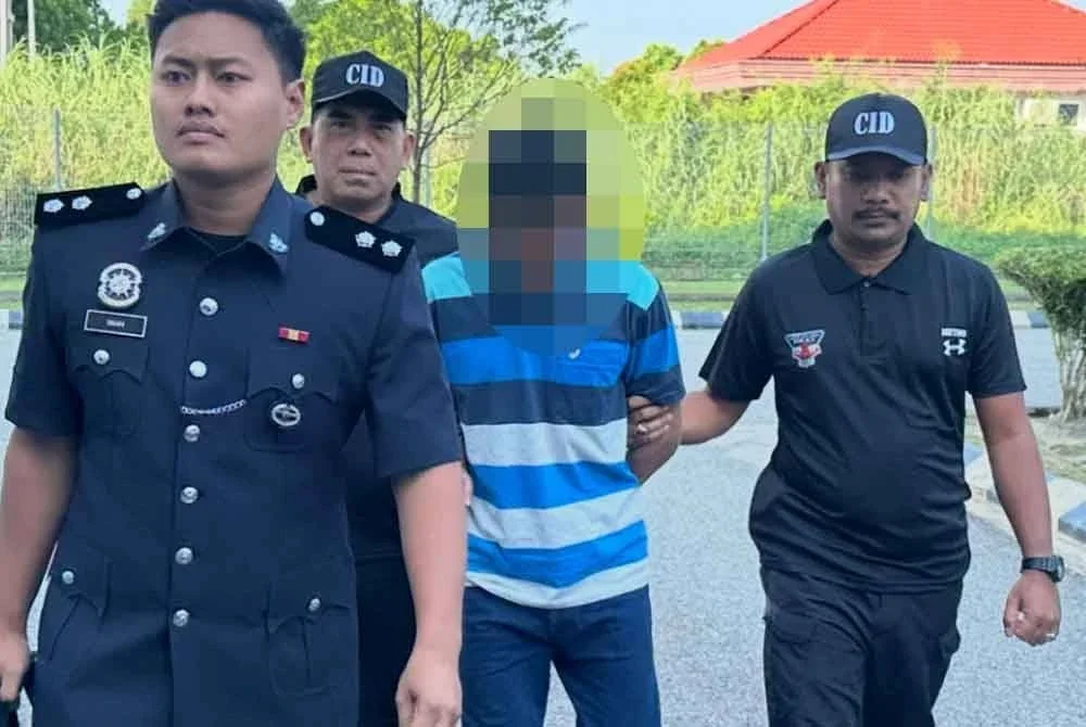 Tertuduh (dua dari kanan) dikawal ketat polis ketika dibawa ke Mahkamah Kota Bharu.
