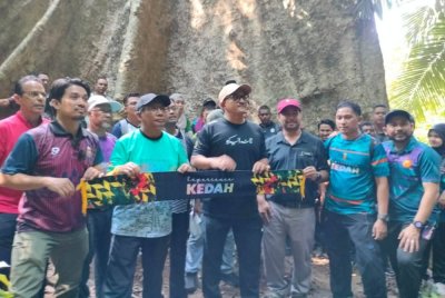 Mohd Salleh (tengah) ketika meninjau pokok berusia lebih 100 tahun.