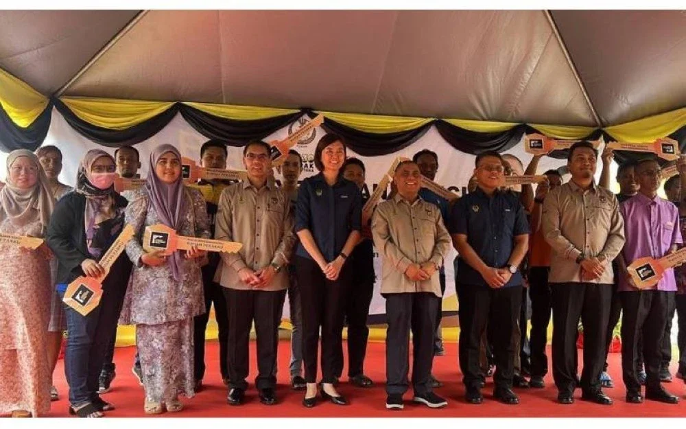 Menteri Besar Perak, Datuk Seri Saarani Mohamad (empat dari kanan) dan Mohamed Akmal (tiga dari kanan) bersama pemilik rumah ketika Majlis Penyerahan Kunci Rumah Perakku di Taman Perakku Batu 14, Lekir, Sitiawan baru-baru ini.